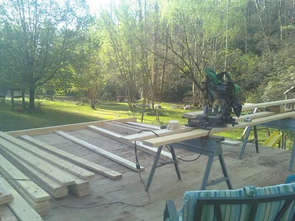 Miter saw and framing lumber on a deck under construction in Sterling